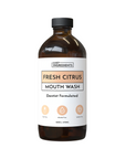 Brown glass bottle of Fresh Citrus mouth wash with a white label, 16 oz, noting it's dentist formulated and free from dyes, a