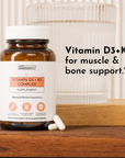 Amber glass bottle of Vitamin D3+K2 Complex supplement with white label next to clear glass container on wooden surface.