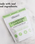 White and green packet of Strawberry Limeade Nighttime Relax with ingredient icons on marble background.