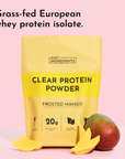 Yellow pouch of Frosted Mango Clear Protein Powder with mango fruit and slices on pink background.
