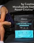 Black and turquoise Creatine Max powder pouch displaying 5g creatine monohydrate, positioned next to person in gym setting.