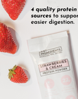 Strawberries and cream protein powder stick next to fresh strawberries on a white background.