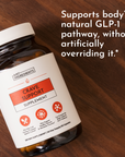 Dark amber glass bottle with white label reading "Crave Support Supplement" and red icons, displayed on wooden surface.