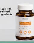 Amber glass bottle with white cap containing Whole Food Vitamin C Complex supplement capsules.