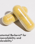 Three yellow capsules filled with powdered supplement on white background.