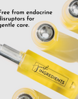 Yellow face serum bottle with a silver cap, labeled "just INGREDIENTS," surrounded by similar bottles.