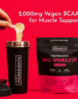 Black shaker bottle and black pouch of Pink Dragon pre-workout powder with powder being poured into the shaker on a red backg