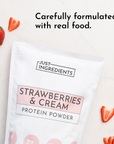 White pouch of "Strawberries & Cream Protein Powder" with strawberries scattered around on a marble surface.