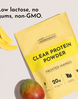 Yellow packet of Frosted Mango Clear Protein Powder with mango slices and whole mango displayed nearby.