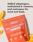 Bright orange packaging of "Brain + Energy Boost" stick with blood orange slices beside it, featuring text about ingredients.