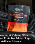 Black and orange pouch of Strawberry Tropic Performance Electrolytes with nutrition facts displayed on dark background near e