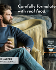 Man holding caramel latte drink seated next to black Bryce's Caramel Latte Protein Powder package.