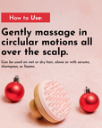 Scalp scrubber with a pink rubber head and wooden handle, placed next to red holiday ornaments on a pink background.