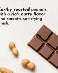 Roasted peanuts and a chocolate bar are displayed on a light surface.