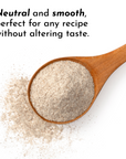 Wooden spoon filled with beige protein powder on white background with scattered powder.