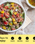Bowl of quinoa salad with tomatoes, cucumbers, yellow peppers, and herbs, accompanied by a small dish of oil.