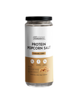 Clear jar of protein popcorn salt labeled "Caramel Corn," featuring nutritional information and serving details.