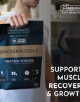 A person holds a black protein powder bag labeled "Snickerdoodle" with nutritional information and benefits displayed.