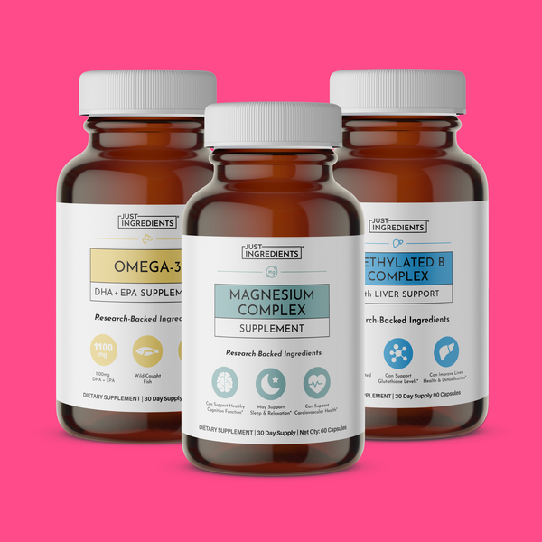 Three brown glass supplement bottles with white caps labeled Omega-3, Magnesium Complex, and Methylated B Complex on pink bac