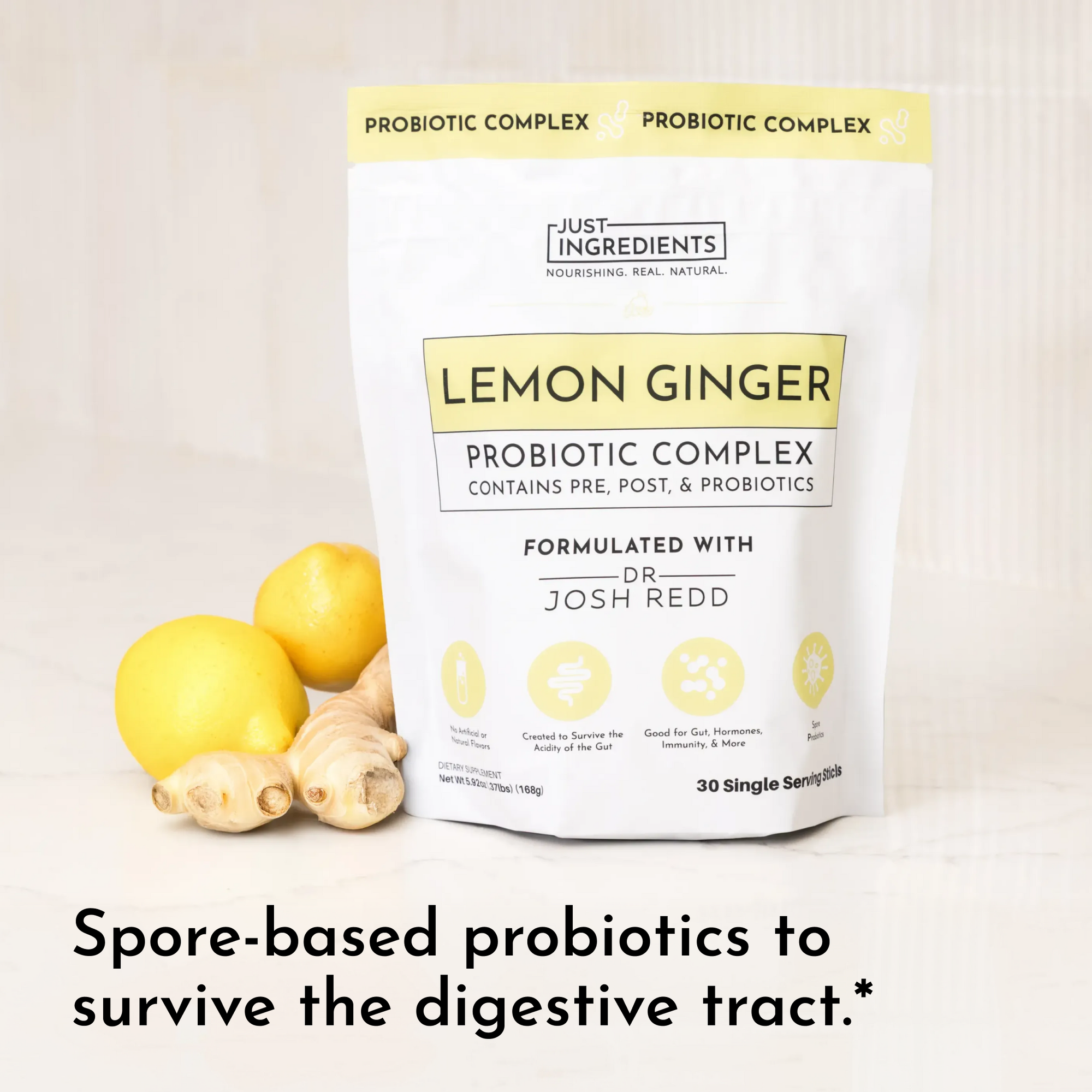 White pouch labeled "Lemon Ginger Probiotic Complex" with lemons and ginger root beside it, featuring product details.