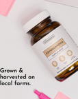 Brown glass bottle with white cap containing ashwagandha supplement capsules, labeled "Just Ingredients Ashwagandha Supplemen