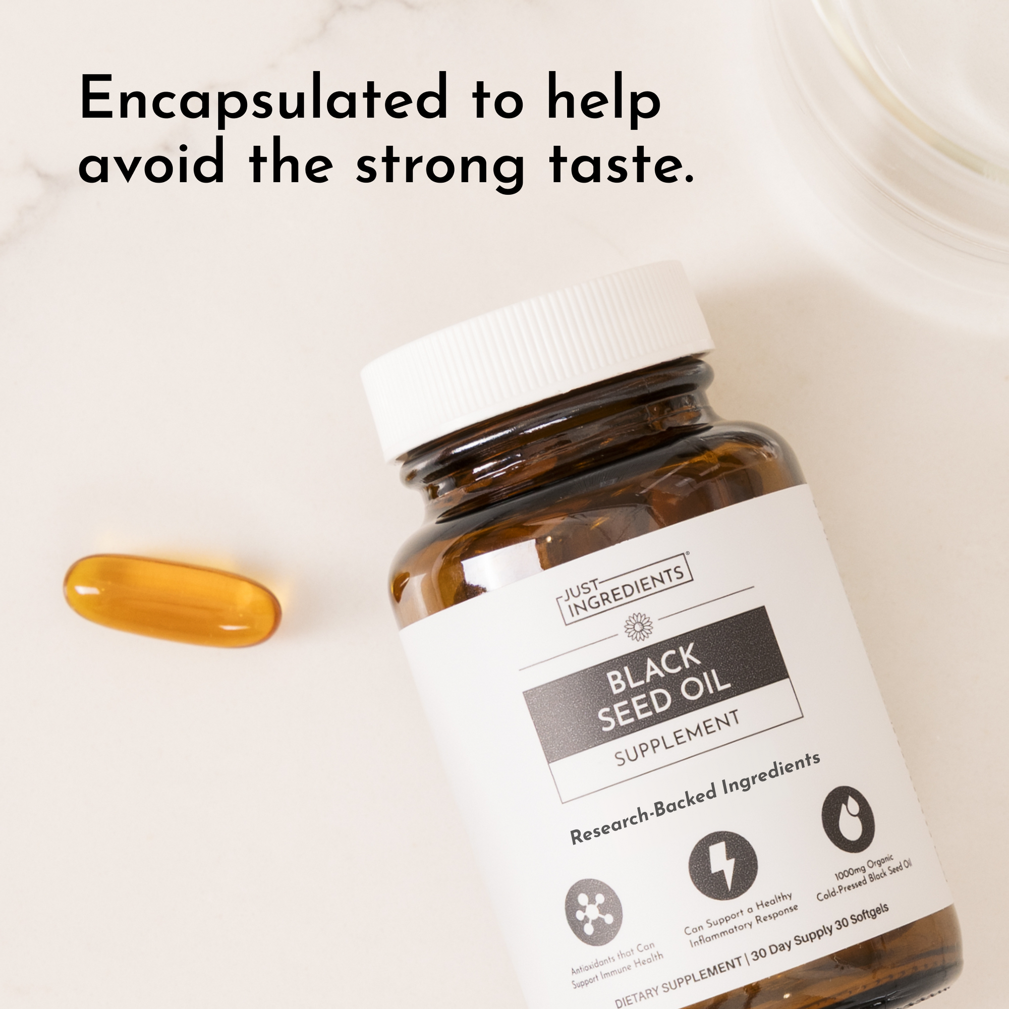 Amber glass bottle of black seed oil supplement capsules with white label and one golden capsule displayed beside it.