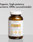 Amber glass bottle of Turmeric Complex supplement with white cap and label on gray background.