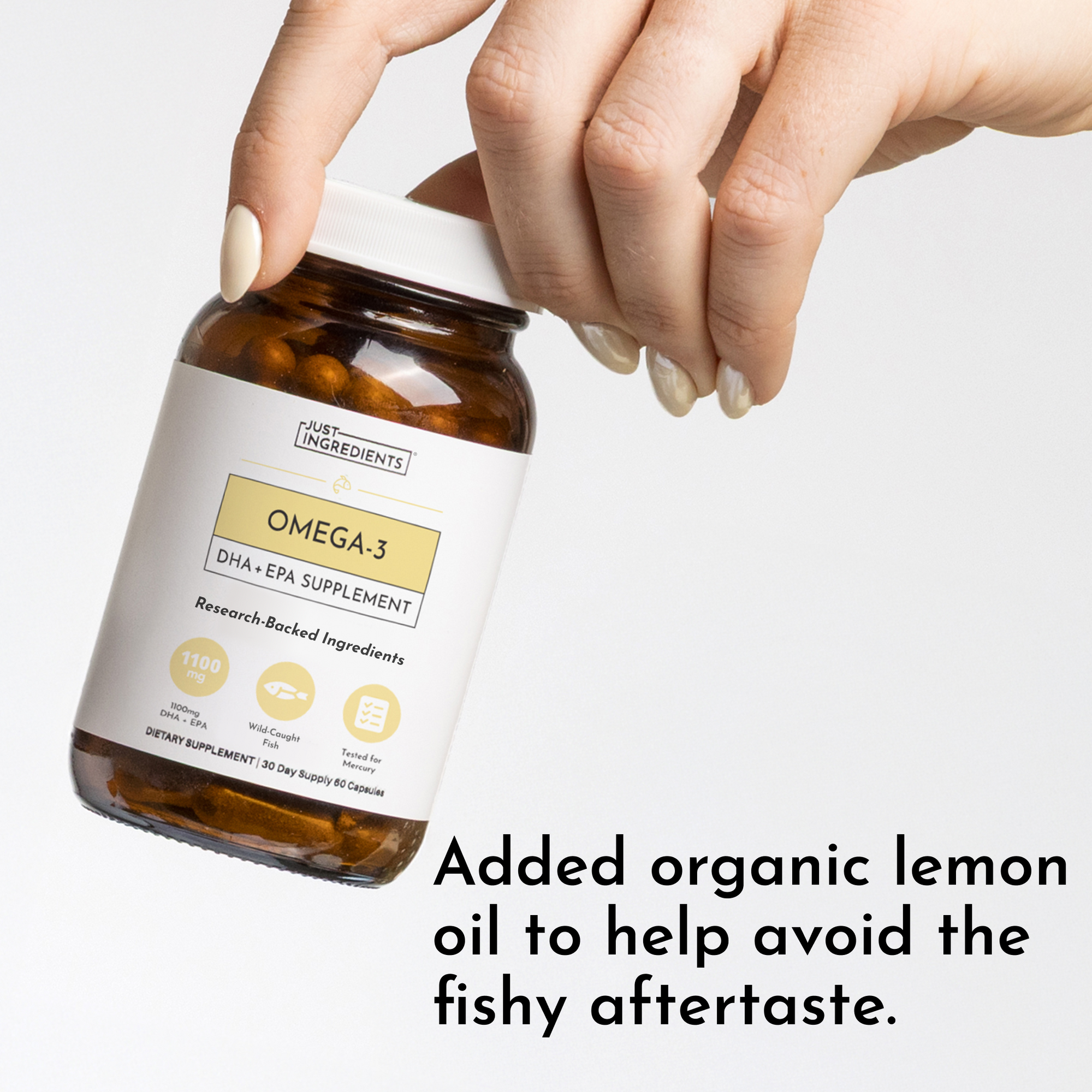 Hand holding amber glass bottle of Omega-3 DHA+EPA supplement with white label.