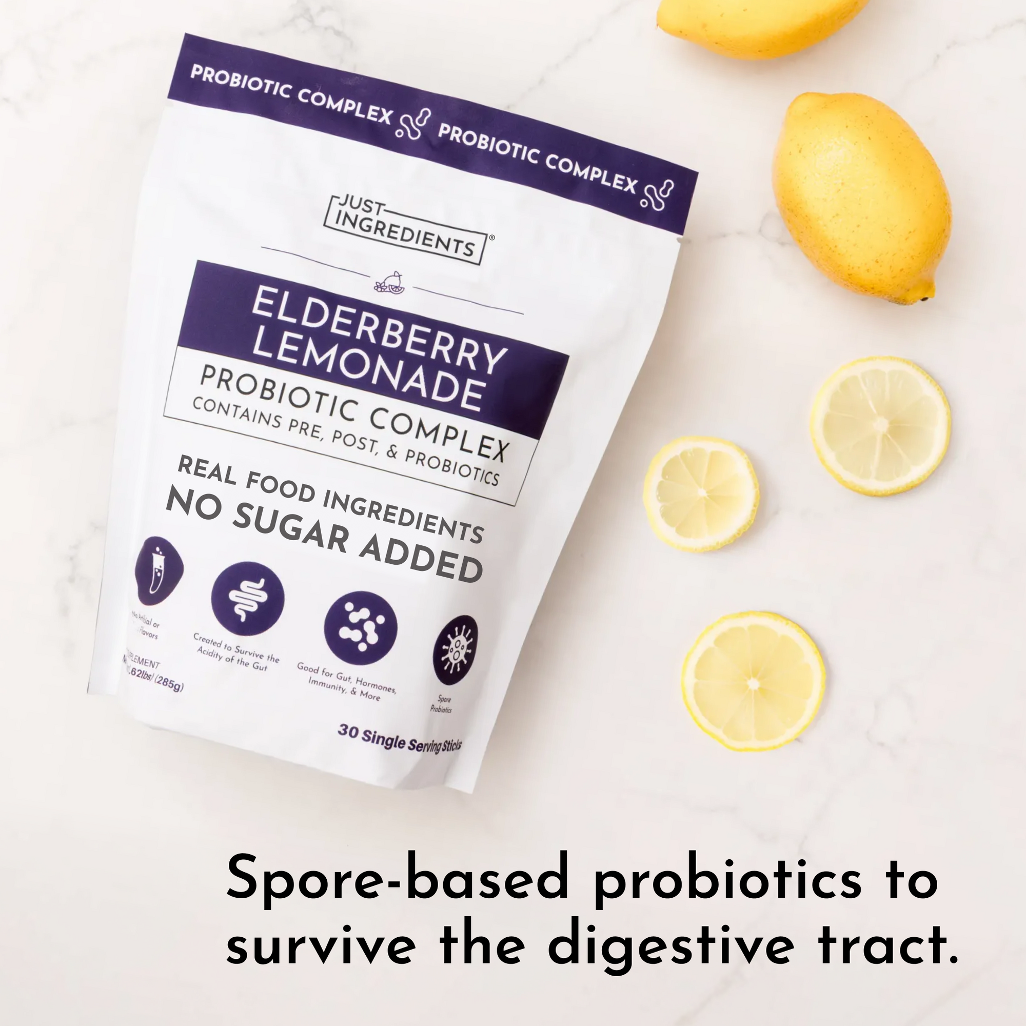 White pouch with purple accents labeled "Elderberry Lemonade Probiotic Complex" surrounded by fresh lemons on marble surface.