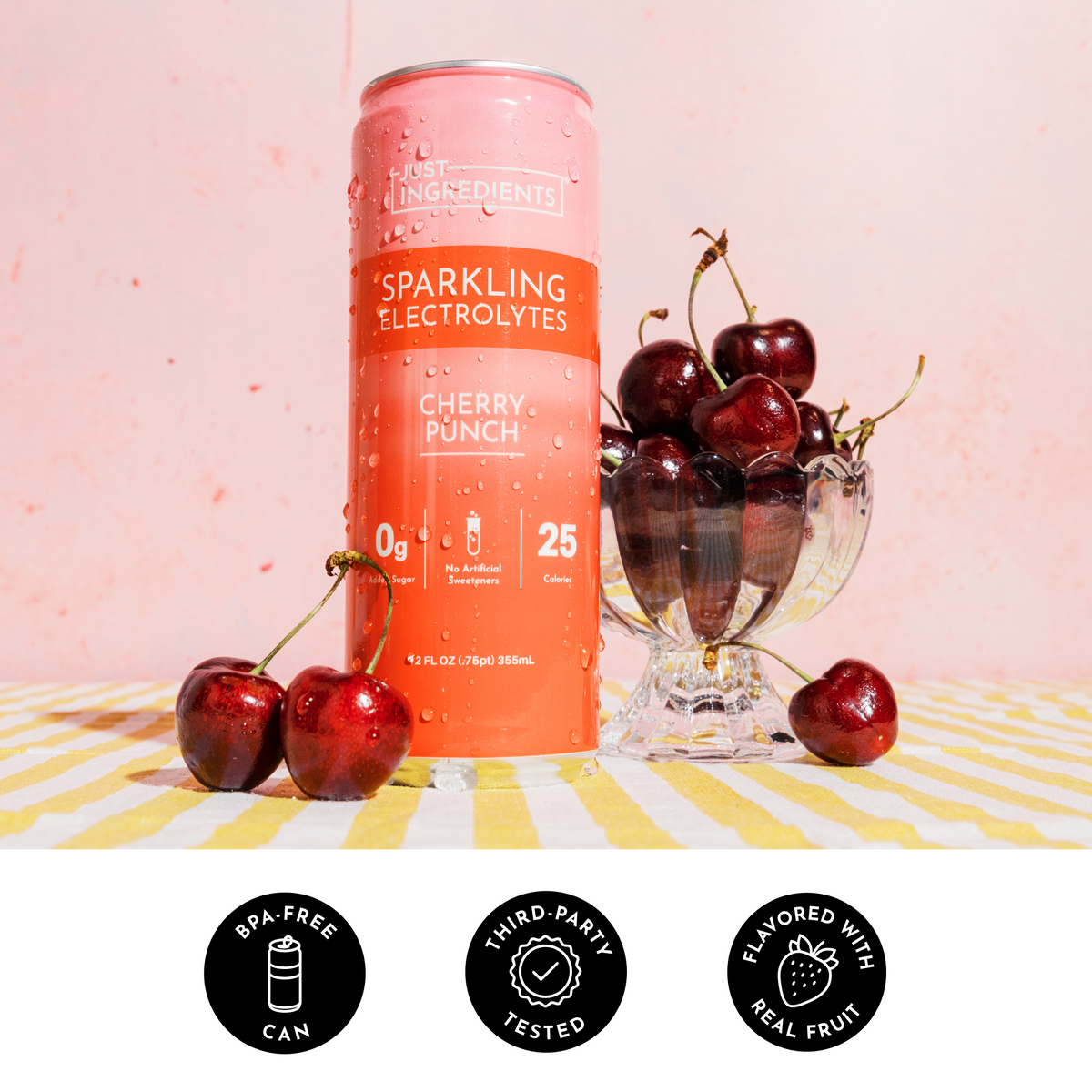 Red aluminum can of Cherry Punch Sparkling Electrolytes surrounded by fresh dark red cherries in a glass bowl on striped surf