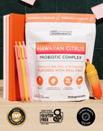White pouch of Hawaiian Citrus Probiotic Complex with orange accents, surrounded by orange notebooks, colored pens, and a jui