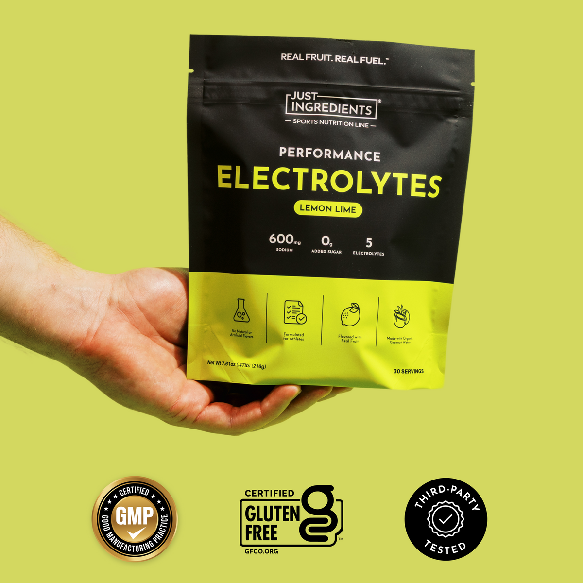 Black and yellow pouch of Lemon Lime Performance Electrolytes held in hand against yellow background, with GMP certified and 