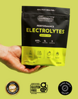 Black and yellow pouch of Lemon Lime Performance Electrolytes held in hand against yellow background, with GMP certified and 