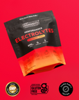 Black and orange electrolyte powder packets labeled "Strawberry Tropic" with "Just Ingredients" branding on red background.