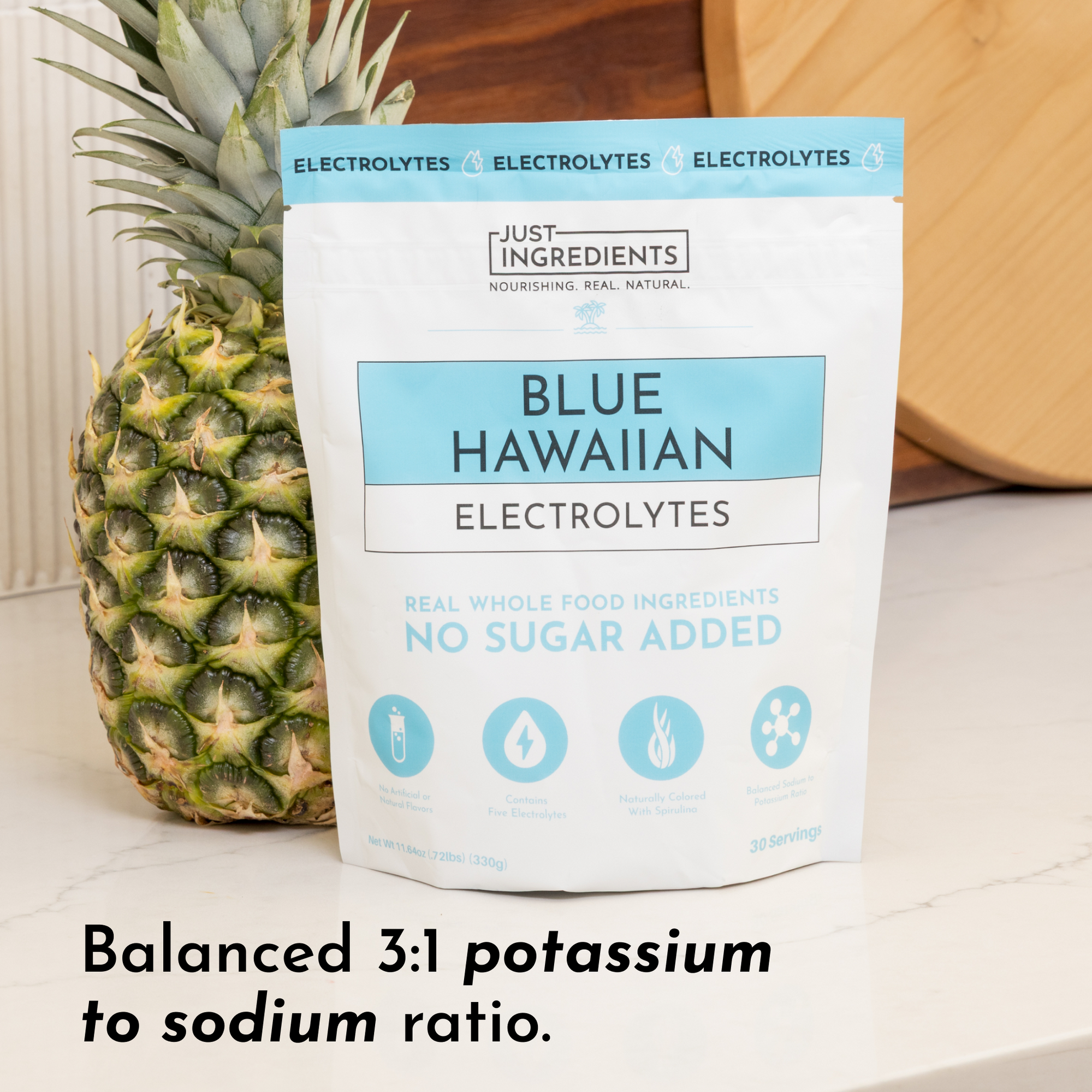 Pouch of Blue Hawaiian Electrolytes next to a pineapple, featuring a 3:1 potassium to sodium ratio.