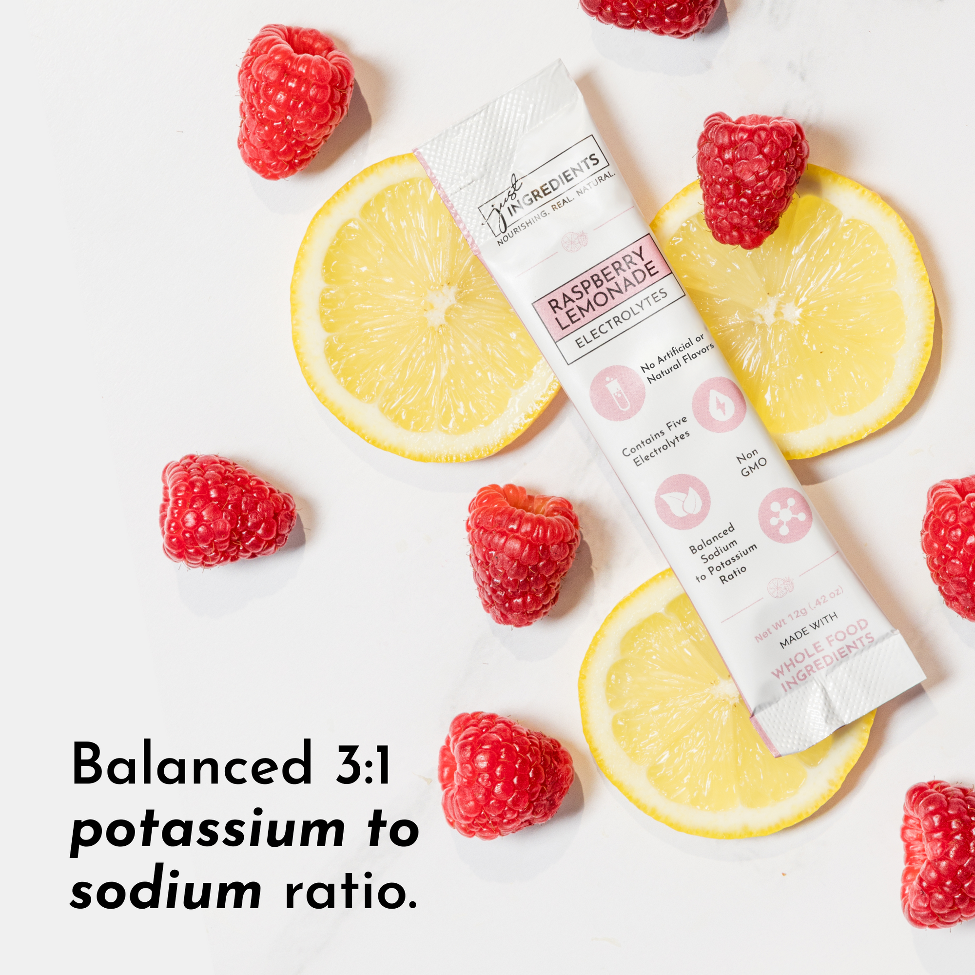 Electrolyte stick surrounded by fresh raspberries and lemon slices on a white background.