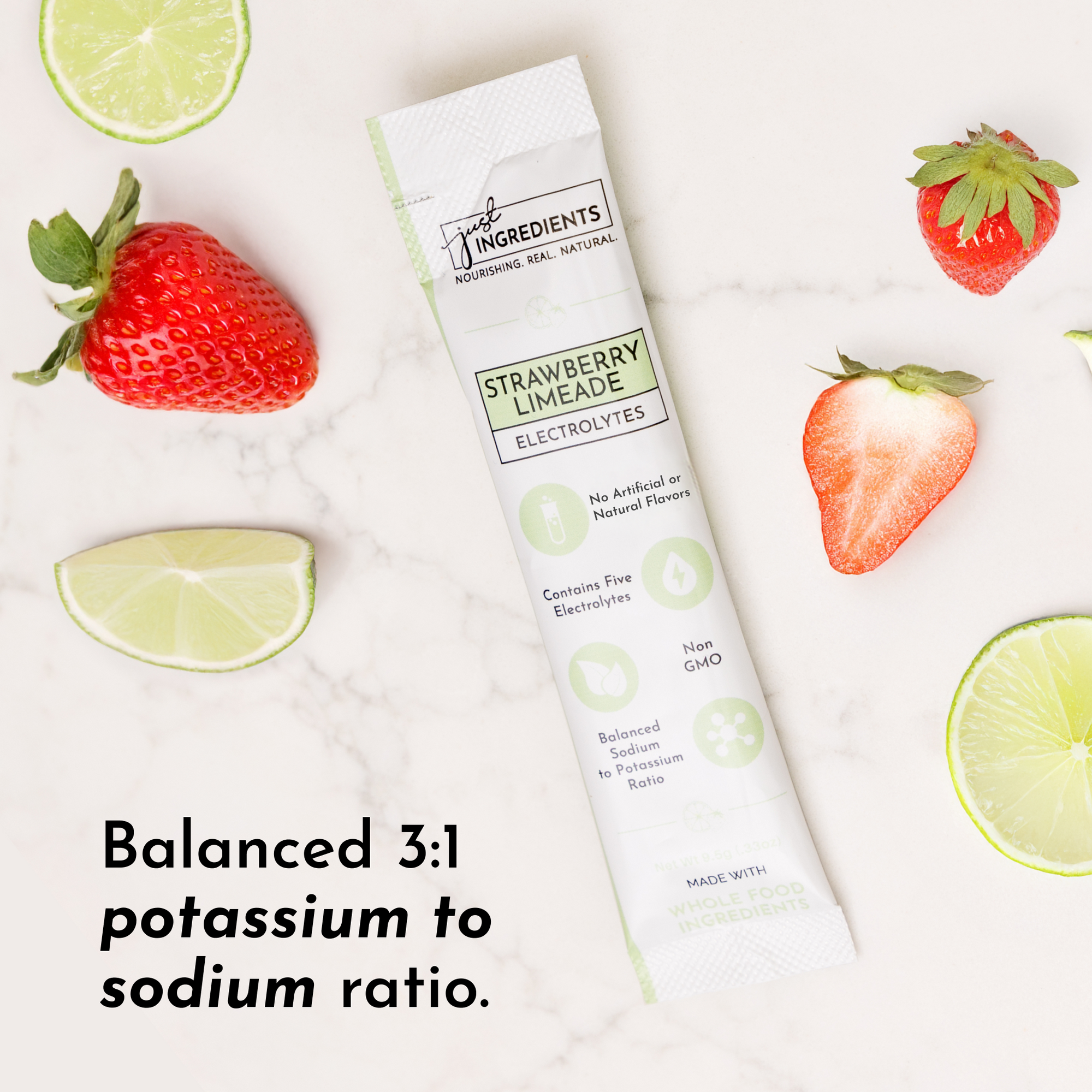 Electrolyte stick packet with strawberry and lime slices on a marble surface.