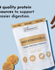 Vegan Snickerdoodle protein powder bag with cookies and cinnamon sticks on a light blue background.