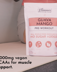 White pouch of Guava Mango pre-workout powder with pink label showing "no sugar added" and ingredient icons, 30 servings.