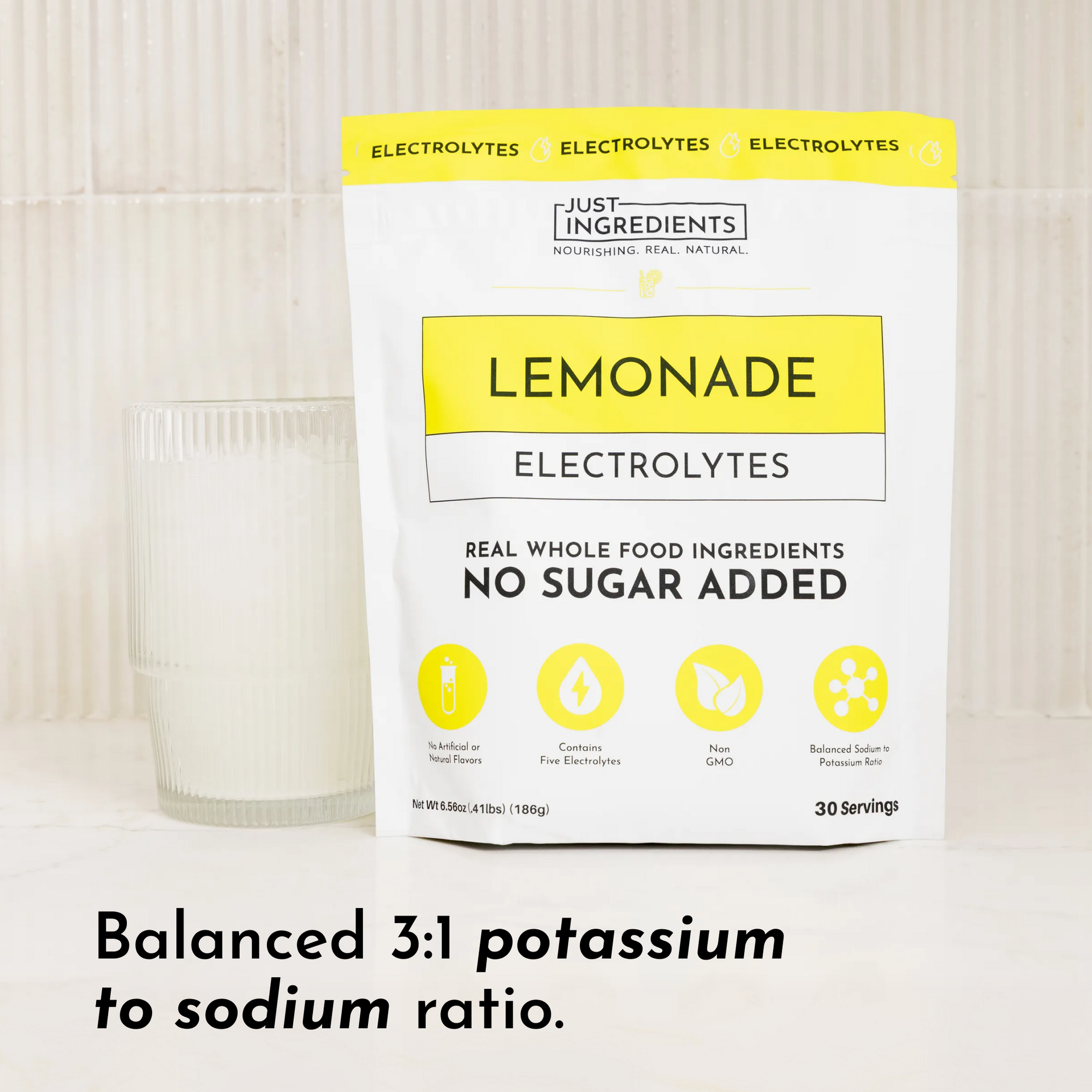 Pouch of Lemonade Electrolytes with a glass of liquid beside it, featuring a yellow and white design.