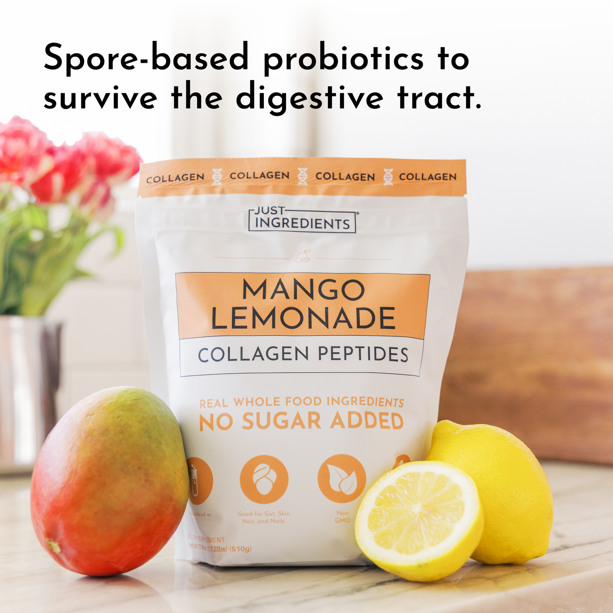 White pouch of Mango Lemonade Collagen Peptides with a mango and sliced lemon beside it on a marble surface.