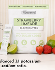 Pouch of Strawberry Limeade electrolytes with a single packet, fresh strawberries, and lime halves on a countertop.