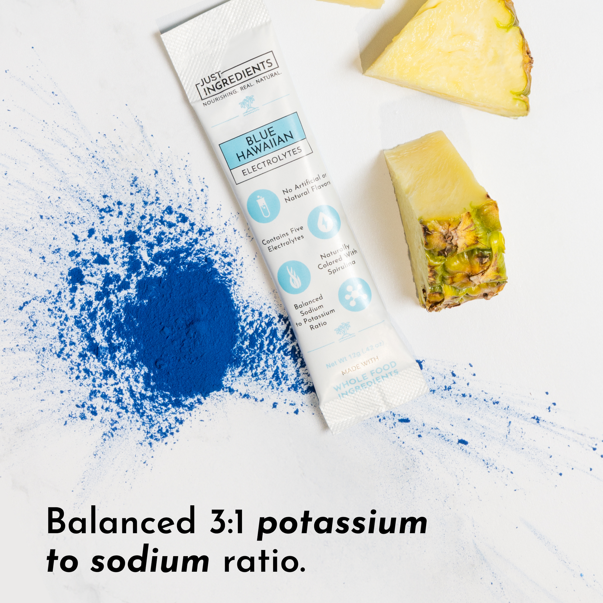 Blue powder scattered on a surface next to a stick packet and pineapple pieces.