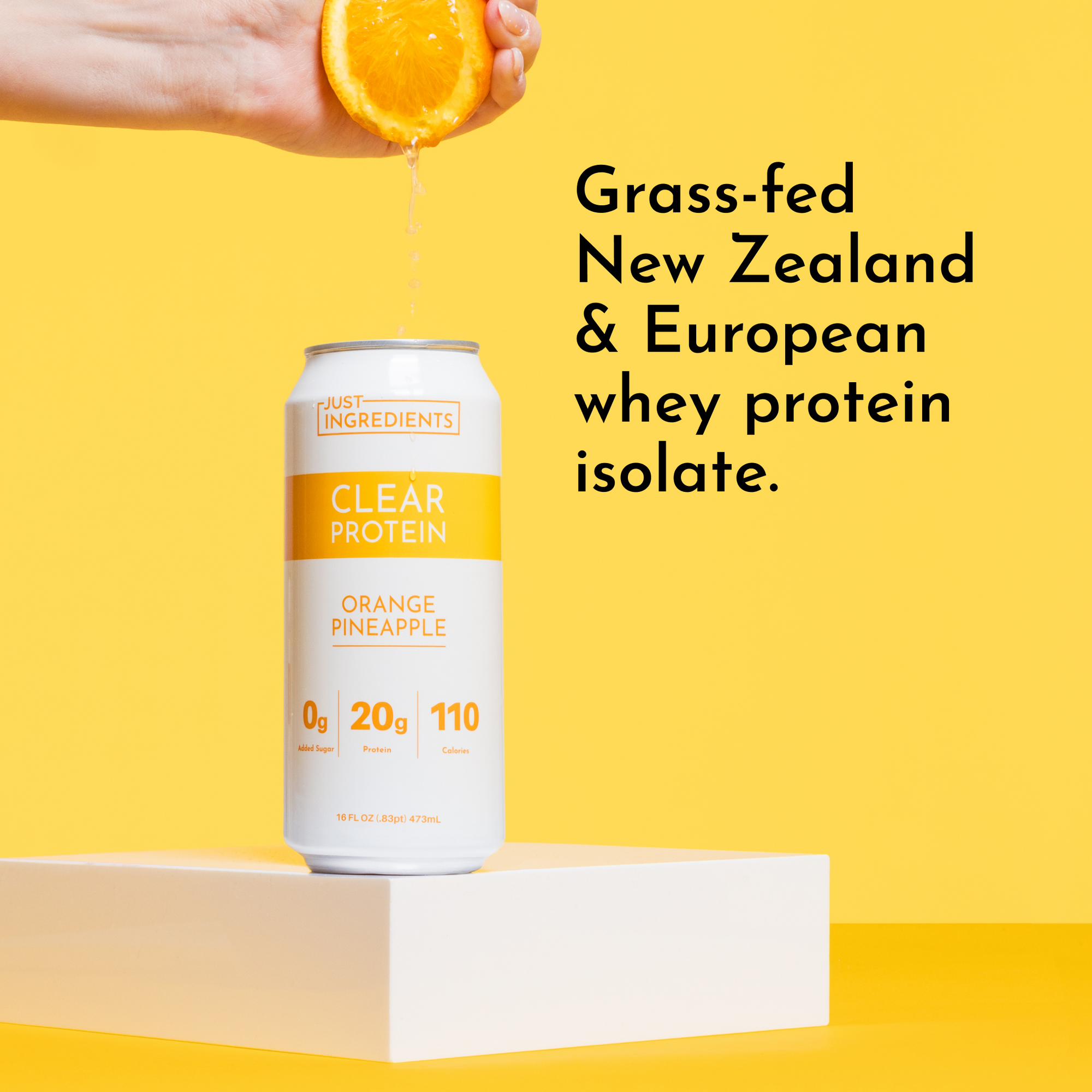 A hand squeezes an orange above a can of Clear Protein in Orange Pineapple flavor on a yellow background.