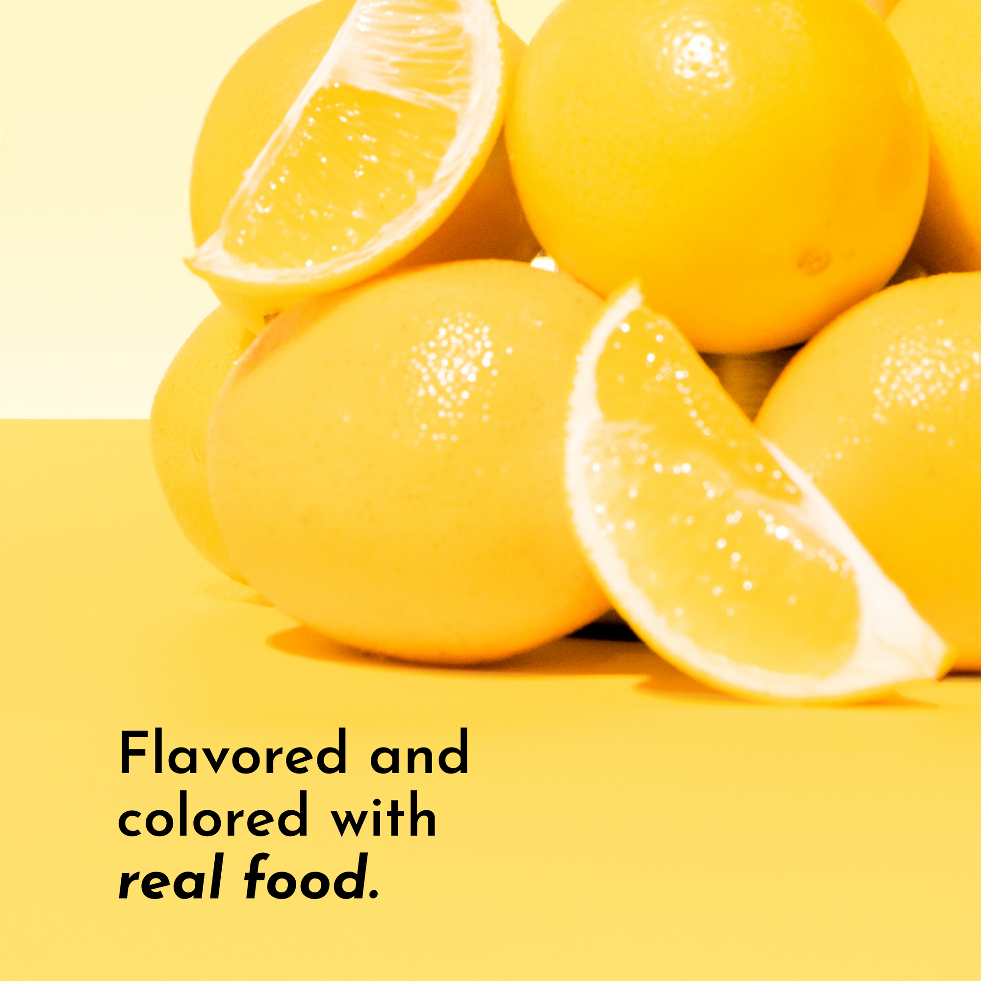 A stack of whole lemons and lemon slices on a yellow background with text about real food flavoring.
