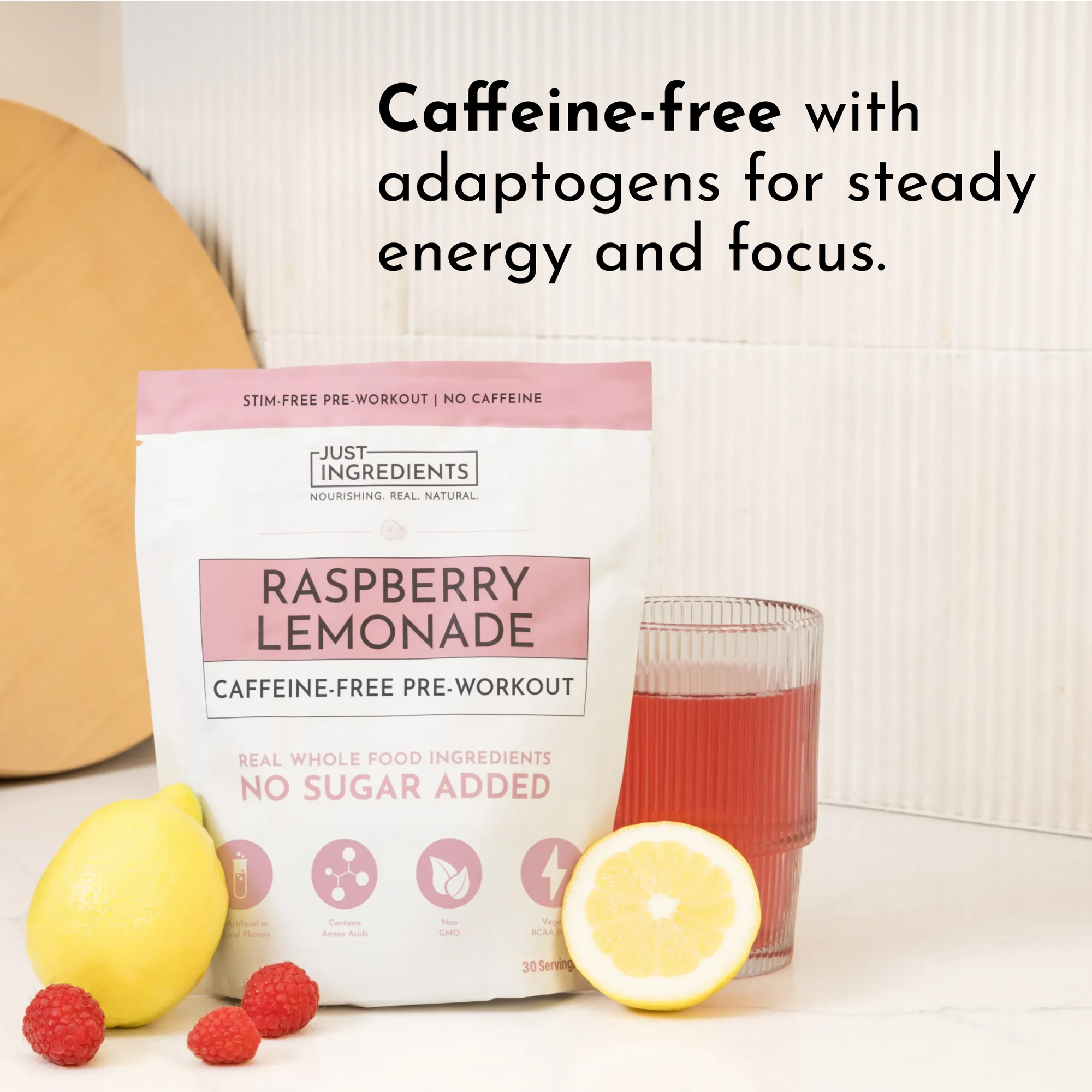 Caffeine-free raspberry lemonade pre-workout powder in a bag with a glass of drink and fresh lemon and raspberries.