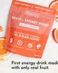 Bright orange packaging of "Brain + Energy Boost Blood Orange" with sliced blood oranges on a white surface.