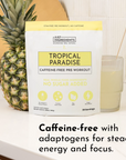 Caffeine-free pre-workout powder package next to a pineapple and a glass of light yellow drink on a countertop.