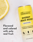 Yellow can of lemonade energy drink next to a lemon slice on a light surface.