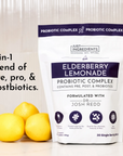 White pouch labeled "Elderberry Lemonade Probiotic Complex" with three lemons in front, featuring nutritional information.
